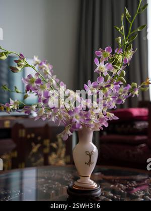 Una splendida disposizione in orchidea viola in un elegante vaso Foto Stock