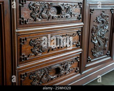 Cassetti in legno finemente intagliati con un motivo a forma di drago Foto Stock