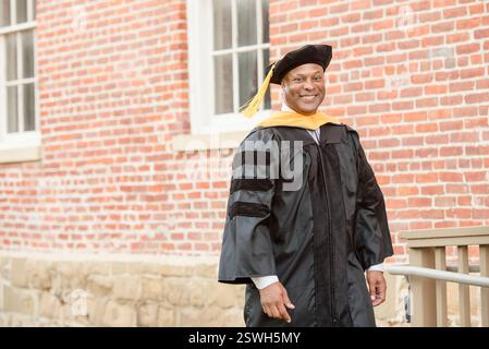 Orgoglioso laureato in insegne accademiche, che celebra una pietra miliare Foto Stock