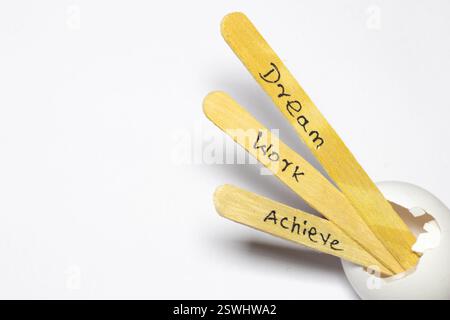 primo piano di un messaggio scritto a mano su un bastoncino a poppa che indica sogno, lavoro e realizzazione Foto Stock