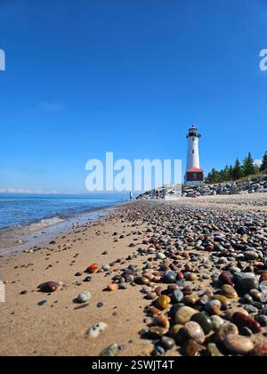 Spiaggia sabbiosa di ciottoli che conduce al Crisp Point Lighthouse Foto Stock