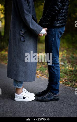 Due cuori che camminano fianco a fianco, tenendosi per mano. Questo semplice gesto contiene tutto il potere dell'amore, della fiducia e della tenerezza. Foto Stock