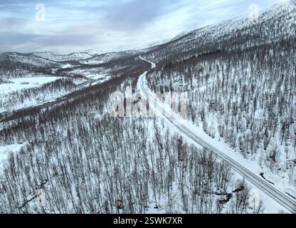 Sorvola una strada di campagna nel paesaggio innevato della tundra dell'isola di Senja nel nord della Norvegia Foto Stock