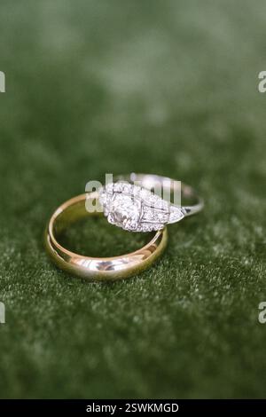 Due splendidi anelli poggiano su un morbido sfondo verde, mettendo in risalto la bellezza dell'amore e l'impegno eterno. Foto Stock