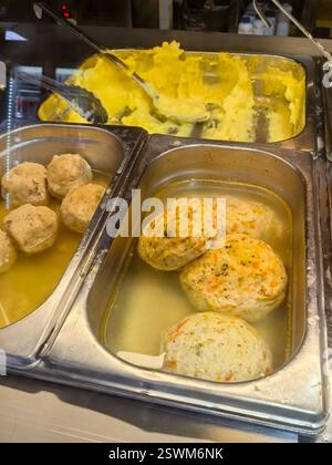 Un'allettante esposizione di gnocchi appena fatti si trova in un brodo caldo accanto a una generosa porzione di crema di patate. Questo cibo di conforto, perfetto per Foto Stock