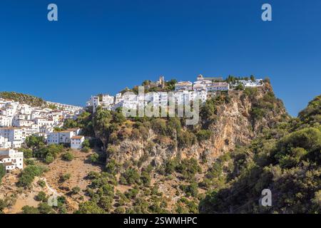Casares in Andalusia, Spagna, Europa. Villaggio bianco arroccato sulla cima di una spettacolare scogliera, bagnato dalla luce del sole sotto un cielo azzurro. Foto Stock