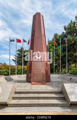 Baku, Azerbaigian - 6 maggio 2024: Il Memoriale dei Martiri turchi, si erge alto con le bandiere turche e azere che sventolano nella brezza. Il monumento è un simbolo di memoria e sacrificio Foto Stock