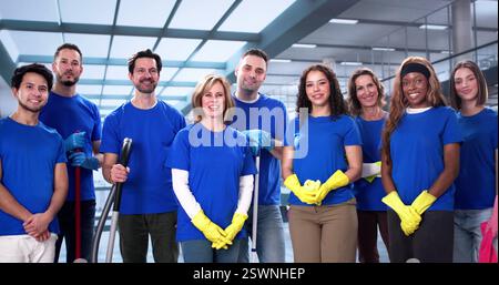 Team di pulizia multirazziale che fornisce servizi di pulizia professionali per ufficio con Smile Foto Stock