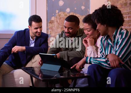 Team di startup che utilizza un tablet per lo sviluppo di progetti nello spazio di coworking Foto Stock