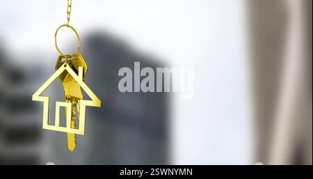Immagine del portachiavi della casa dorata su sfondo sfocato del paesaggio urbano Foto Stock