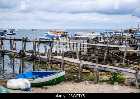 Tranquillo molo in legno che si estende sul lago Titicaca al porto di Copacabana Bolivia con barche Foto Stock