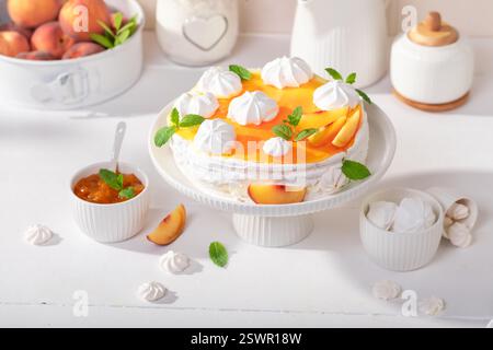 Meringa dolce di pesca servita come dessert per la primavera. Meringa di pesca con frutta e zucchero di caster. Foto Stock