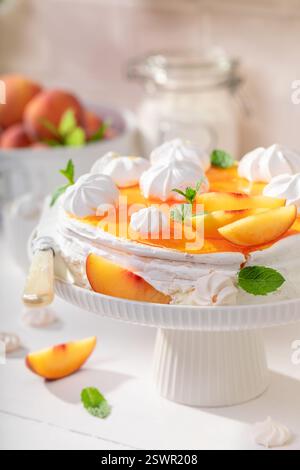 Meringa di pesca fatta in casa servita come dessert per la primavera. Meringa di pesca fatta di panna e frutta. Foto Stock