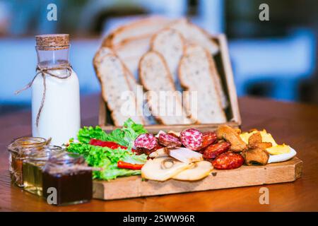 Ampia scelta di piatti per la colazione, tra cui pane, latte, salsicce, lattuga e funghi esposti. Foto Stock