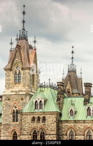 Grande edificio con un tetto verde e una torre dell'orologio. L'edificio ha un tetto verde, che è un tipo di tetto realizzato con materiali come piastrelle, ardesia o m. Foto Stock