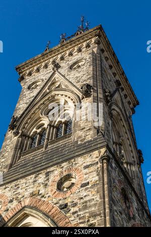Alta torre in mattoni con un orologio in cima. L'orologio è bianco e nero. La torre è circondata da finestre Foto Stock