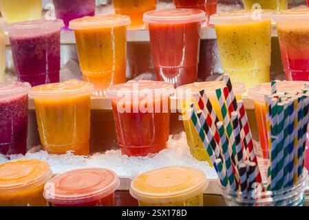 Porto, Portogallo, 23 dicembre 2024: Assaggia l'arcobaleno: Frullati freschi sul ghiaccio al mercato di Bolhão Foto Stock