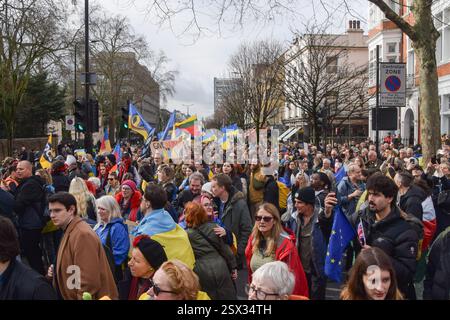 Londra, Regno Unito. 22 febbraio 2025. La folla si riunisce con le bandiere ucraine durante la manifestazione fuori dall'ambasciata russa. Centinaia di persone hanno marciato verso l'ambasciata russa in solidarietà con l'Ucraina in vista del terzo anniversario dell'attacco da parte della Russia. Credito: SOPA Images Limited/Alamy Live News Foto Stock