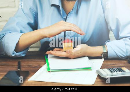 Donna d'affari o agente immobiliare e in possesso di una casa modello Foto Stock