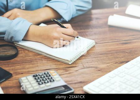 Donna freelancer mani femminili con penna scrittura su notebook a casa o in ufficio Foto Stock