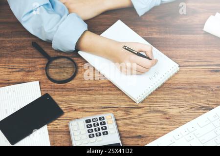 Donna freelancer mani femminili con penna scrittura su notebook a casa o in ufficio Foto Stock