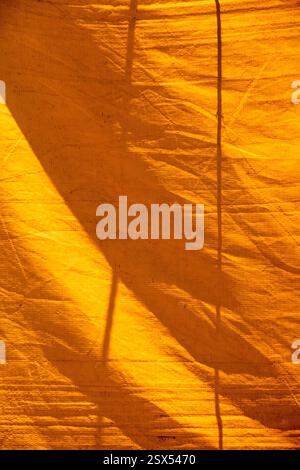 Texture colorata di una vecchia tenda da circo che forma figure grafiche gialle e arance. Composizione di strutture astratte su tela Foto Stock