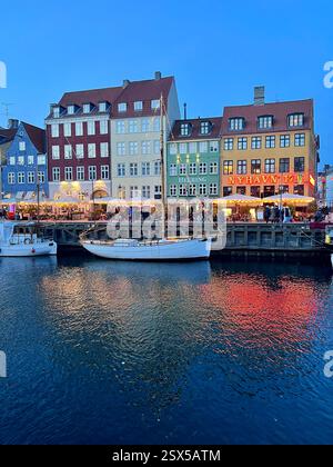 Nyhavn è un lungomare del XVII secolo, canale e quartiere dei divertimenti a Copenaghen, Danimarca. Architettura tradizionale e riflesso della luce nell'acqua Foto Stock