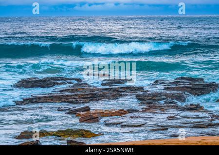Coperto Sunrise Seascape con rocce e onde ad Avalon sulle spiagge settentrionali di Sydney, NSW, Australia. Foto Stock
