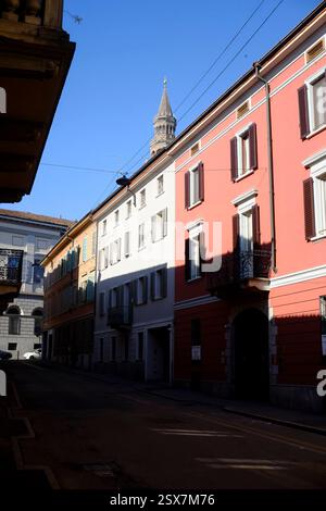 Cremona, Italia 9 febbraio 2025 tradizionale via italiana con edifici colorati e il torrazzo campanile del Duomo Foto Stock