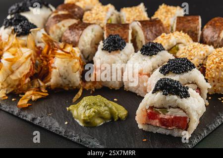 Un piatto ben disposto presenta una varietà di sushi panini conditi con caviale e guarniti con wasabi. Il pasto include ingredienti freschi Foto Stock