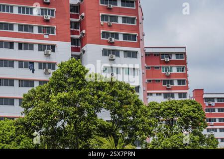 Singapore City, Singapore, 22 gennaio 2019: Vista ad angolo basso di un alto edificio di appartamenti in mattoni bianchi e rosa con aria condizionata montata sotto vittoria Foto Stock