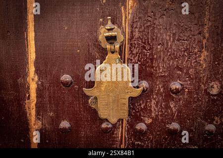 Maniglia a forma di Fatima a mano sulla vecchia porta in legno in Marocco Foto Stock