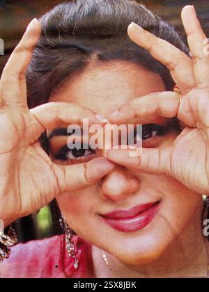 Poster cinematografico di Dhallywood a Dacca, Bangladesh, con una donna sorridente che inquadra scherzosamente gli occhi con le dita in uno scatto ravvicinato. Foto Stock