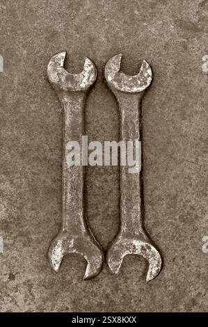 Una grande e una piccola chiave arrugginita appoggiate su metallo opacizzato Foto Stock