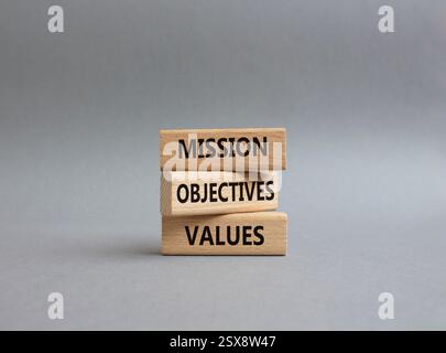 Simbolo dei valori degli obiettivi della missione. Parole concettuali obiettivi della missione valori su blocchi di legno. Splendido sfondo grigio. Obiettivi aziendali e di missione Foto Stock