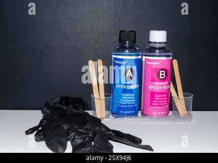 Belfast Contea di Down Irlanda del Nord 16 febbraio 2025 - bottiglie di resina epossidica Teexpert e indurente su base bianca e fondo nero Foto Stock