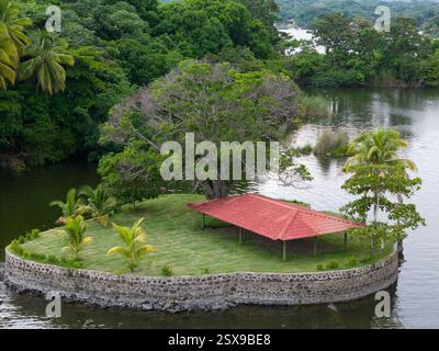 Piccola isola vuota con erba verde e vista aerea dell'edificio con tetto rosso Foto Stock