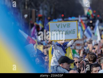 Saint Ouen, Parigi, Francia. 23 febbraio 2025. I manifestanti marciano con cartelli e bandiere ucraine durante una manifestazione a sostegno dell'Ucraina alla vigilia del terzo anniversario dell'invasione russa del paese, a Parigi il 23 febbraio 2025. (Credit Image: © Sadak Souici/ZUMA Press Wire) SOLO PER USO EDITORIALE! Non per USO commerciale! Crediti: ZUMA Press, Inc./Alamy Live News Foto Stock