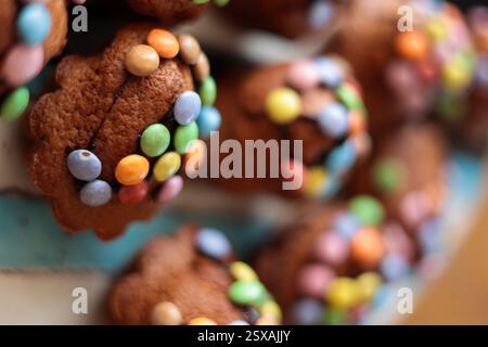 Muffin pasquali decorati con glassa e bonbon colorati con sfondo sfocato Foto Stock