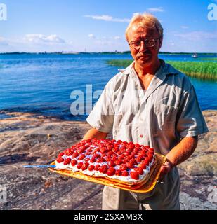 Uomo con torta alle fragole Foto Stock