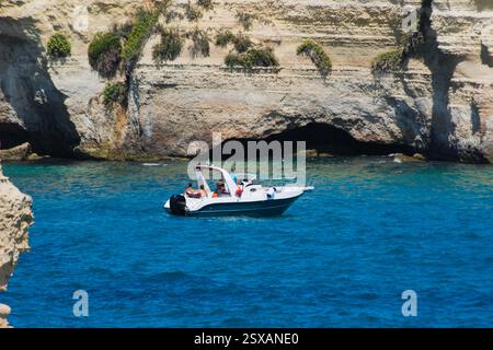 Barca turistica vicino alla scogliera di Torre Sant'Andrea, costa salentina, Puglia, ITALIA Foto Stock