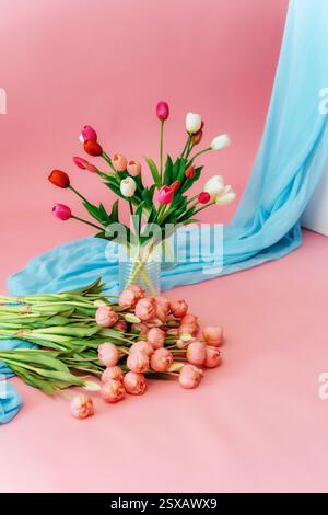 tulipani colorati su sfondo rosa. bouquet di boccioli di tulipano in un vaso di vetro su sfondo colorato Foto Stock