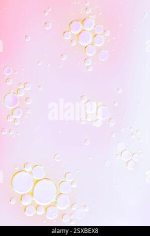 Primo piano, splendido sfondo cosmetico. Bolle d'olio rosa tenue o fondo di siero. Foto macro di bolle d'olio e acqua Foto Stock