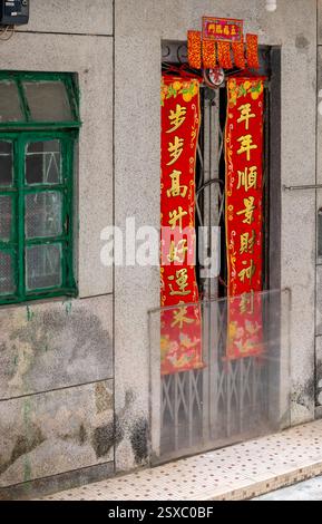 Hong Kong. Cina- 02.13.2025. I giunti di primavera cinesi sono appesi alla porta di una casa del villaggio. Foto Stock