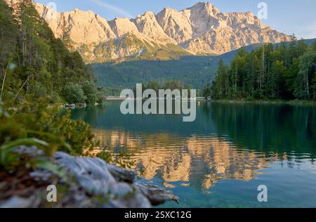 Questa immagine mozzafiato mostra la bellezza serena di Eibsee, un lago alpino annidato ai piedi di Zugspitze, la vetta più alta della Germania. Il Crystal-cl Foto Stock