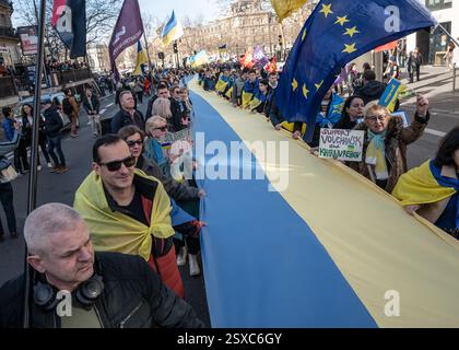 Saint Ouen, Parigi, Francia. 23 febbraio 2025. I manifestanti marciano con cartelli e bandiere ucraine durante una manifestazione a sostegno dell'Ucraina alla vigilia del terzo anniversario dell'invasione russa del paese, a Parigi il 23 febbraio 2025. (Credit Image: © Sadak Souici/ZUMA Press Wire) SOLO PER USO EDITORIALE! Non per USO commerciale! Crediti: ZUMA Press, Inc./Alamy Live News Foto Stock