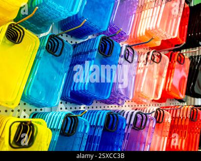 Multicolore trasparente di cover posteriori per smartphone. Custodia colorata fluorescente per cellulare con spazio vuoto per l'obiettivo della fotocamera, appesa ai ganci Foto Stock