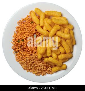 varietà di masala croccanti e piccanti mescolano patatine su fondo bianco isolato, spuntini giallo dorato brillante di lenticchie fritte in profondità con farina e noci Foto Stock
