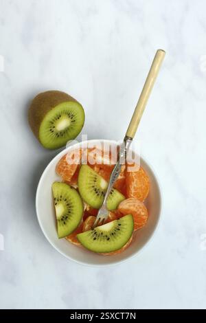 Pezzetti di Clementine e fette di kiwi in buccia Foto Stock