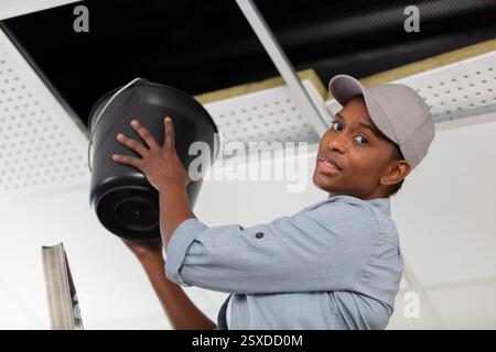 donna che guarda i danni dopo una perdita del tubo dell'acqua Foto Stock